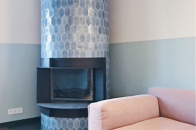 Modelo de salón cerrado actual de tamaño medio con paredes grises, chimeneas suspendidas, marco de chimenea de baldosas y/o azulejos y suelo marrón