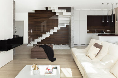 Пример оригинального дизайна: большая открытая гостиная комната в современном стиле с бежевыми стенами, светлым паркетным полом, горизонтальным камином, фасадом камина из дерева, телевизором на стене и бежевым полом