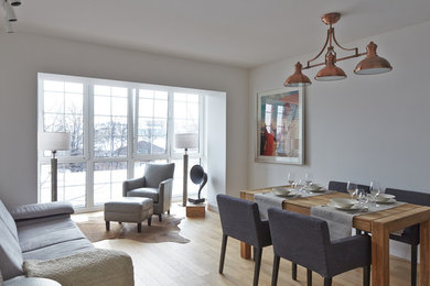 Стильный дизайн: открытая, объединенная гостиная комната среднего размера в скандинавском стиле с с книжными шкафами и полками, белыми стенами, паркетным полом среднего тона и коричневым полом без телевизора, камина - последний тренд