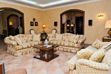 Diseño de salón abierto tradicional renovado grande sin chimenea con paredes beige, suelo de baldosas de porcelana, pared multimedia y suelo beige