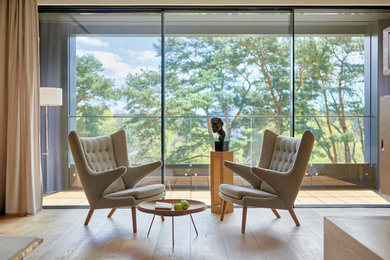 Ispirazione per un soggiorno design di medie dimensioni e aperto con pareti bianche, pavimento in legno massello medio e pavimento marrone