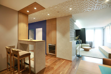 Esempio di un soggiorno design di medie dimensioni e chiuso con angolo bar, pareti marroni, pavimento in legno verniciato, TV a parete e pavimento marrone