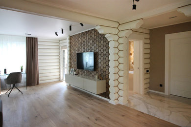 Foto de biblioteca en casa abierta actual grande con paredes blancas, suelo de madera en tonos medios, televisor colgado en la pared y suelo beige