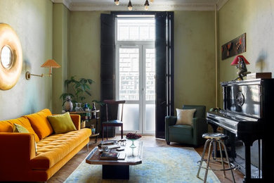 Modelo de salón con rincón musical cerrado retro de tamaño medio con paredes verdes, suelo de madera en tonos medios y suelo beige