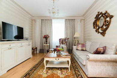 Exemple d'un salon chic de taille moyenne et fermé avec un mur beige, un sol en bois brun, un téléviseur indépendant et un sol marron.