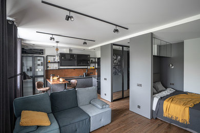 Пример оригинального дизайна: открытая, объединенная гостиная комната в современном стиле с серыми стенами и коричневым полом