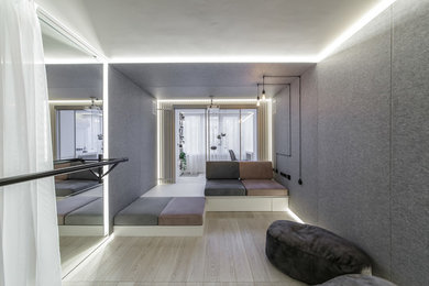 Imagen de salón actual sin chimenea con paredes grises, suelo de madera clara y suelo beige