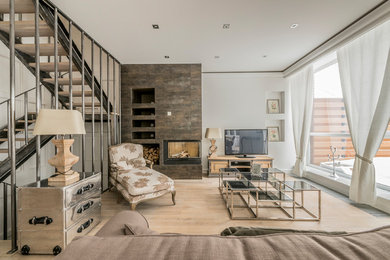 Imagen de salón para visitas abierto contemporáneo con paredes blancas, suelo de madera clara, todas las chimeneas y televisor independiente