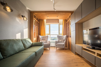 На фото: изолированная гостиная комната в современном стиле с серыми стенами, отдельно стоящим телевизором, паркетным полом среднего тона и коричневым полом