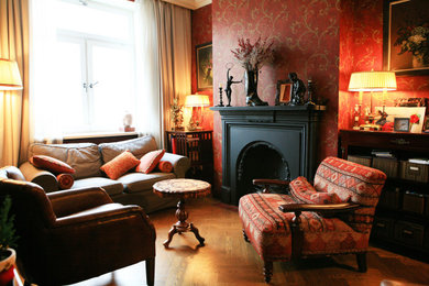 Foto de salón clásico de tamaño medio con paredes rojas, suelo de madera en tonos medios, todas las chimeneas, marco de chimenea de metal y suelo amarillo
