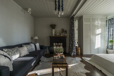 На фото: маленькая гостиная комната с серыми стенами, стандартным камином, фасадом камина из кирпича и телевизором на стене для на участке и в саду с