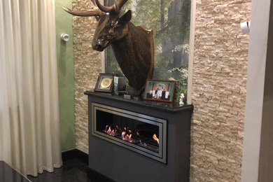 ノボシビルスクにあるお手頃価格の中くらいなモダンスタイルのおしゃれなリビング (標準型暖炉、金属の暖炉まわり) の写真