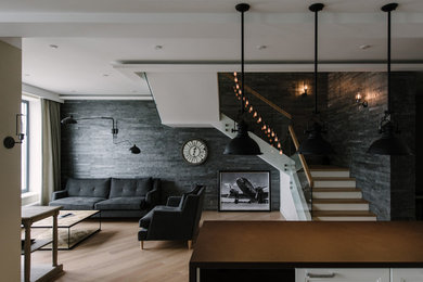 Ejemplo de salón con barra de bar abierto industrial grande con paredes beige, suelo de madera clara, televisor colgado en la pared y suelo beige