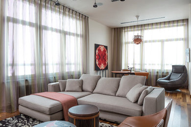 Ejemplo de salón abierto actual de tamaño medio con paredes beige y suelo de madera en tonos medios