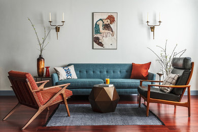 Источник вдохновения для домашнего уюта: парадная, открытая гостиная комната в современном стиле с белыми стенами, темным паркетным полом, коричневым полом и синим диваном