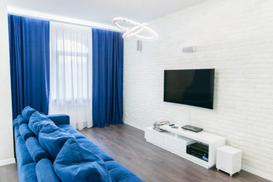 Imagen de salón con barra de bar abierto ecléctico grande con paredes blancas, suelo de madera oscura y televisor colgado en la pared