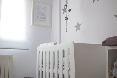 Foto de habitación de bebé neutra nórdica pequeña con paredes blancas y suelo de madera en tonos medios