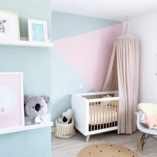Imagen de habitación de bebé niña contemporánea con paredes multicolor, suelo de madera clara y suelo gris