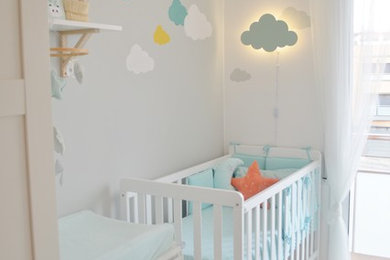 Imagen de habitación de bebé neutra contemporánea pequeña con paredes grises, suelo de baldosas de porcelana y suelo beige