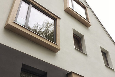 Mittelgroßes, Zweistöckiges Modernes Einfamilienhaus mit Putzfassade, weißer Fassadenfarbe, Satteldach und Ziegeldach in Berlin