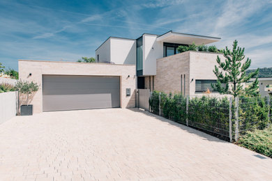 Стильный дизайн: белый частный загородный дом в классическом стиле с облицовкой из камня, плоской крышей и зеленой крышей - последний тренд