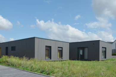 Foto de fachada de casa gris y negra contemporánea de tamaño medio de una planta con revestimiento de madera, tejado plano, techo verde y tablilla