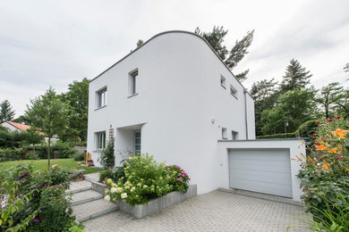 Modernes Einfamilienhaus mit weißer Fassadenfarbe und Flachdach in Berlin