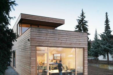 Zweistöckige, Mittelgroße Moderne Holzfassade Haus mit brauner Fassadenfarbe und Flachdach in Sonstige