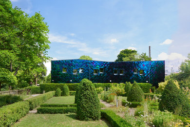 Ejemplo de fachada azul minimalista grande de una planta con revestimiento de madera, tejado plano y tejado de varios materiales