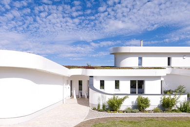Großes, Zweistöckiges Modernes Haus mit Putzfassade, weißer Fassadenfarbe und Flachdach in Sonstige