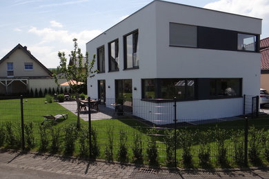 Mittelgroßes, Zweistöckiges Modernes Haus mit Putzfassade, weißer Fassadenfarbe und Flachdach in Bonn