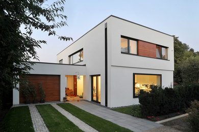Zweistöckiges, Großes Modernes Haus mit Putzfassade, weißer Fassadenfarbe und Flachdach in Berlin