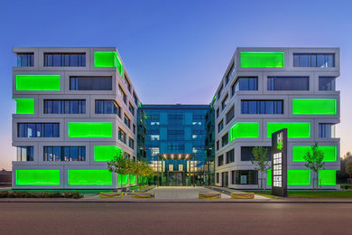 Dreistöckiges Modernes Haus mit Betonfassade, grüner Fassadenfarbe und Flachdach in München