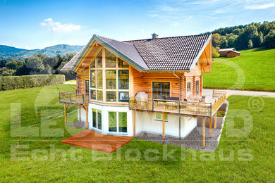 Mittelgroßes, Zweistöckiges Landhausstil Haus mit brauner Fassadenfarbe, Satteldach und Ziegeldach