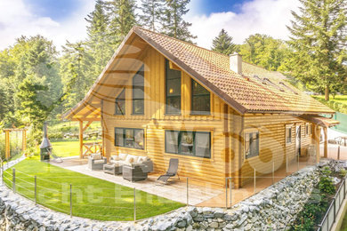 Mittelgroßes, Zweistöckiges Landhausstil Haus mit brauner Fassadenfarbe, Satteldach und Ziegeldach