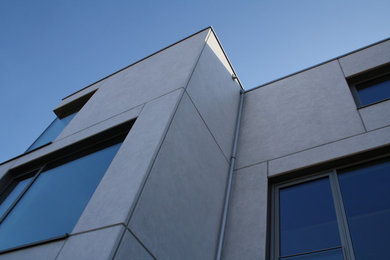 Dreistöckiges Modernes Haus mit Betonfassade, weißer Fassadenfarbe und Flachdach in Bremen