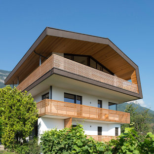 Immagine della villa multicolore moderna a tre piani con tetto a capanna e rivestimento in stucco