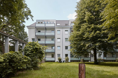 Großes, Dreistöckiges Modernes Wohnung mit Putzfassade, weißer Fassadenfarbe, Satteldach und Ziegeldach in Hamburg
