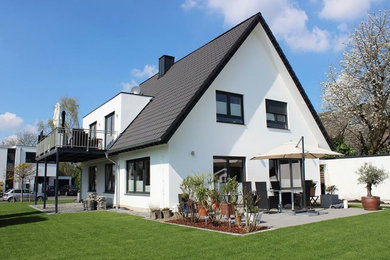 Mittelgroßes, Einstöckiges Modernes Einfamilienhaus mit Putzfassade, weißer Fassadenfarbe, Satteldach und Ziegeldach in Düsseldorf