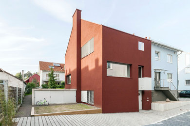 Mittelgroßes, Zweistöckiges Modernes Reihenhaus mit Putzfassade, roter Fassadenfarbe und Satteldach in Stuttgart
