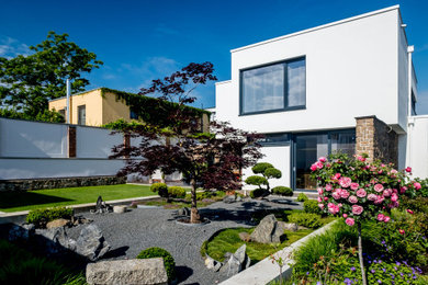 Mittelgroßes, Zweistöckiges Modernes Einfamilienhaus mit Betonfassade, weißer Fassadenfarbe und Flachdach in Sonstige