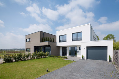 Mittelgroßes, Zweistöckiges Modernes Haus mit weißer Fassadenfarbe und Flachdach in Köln
