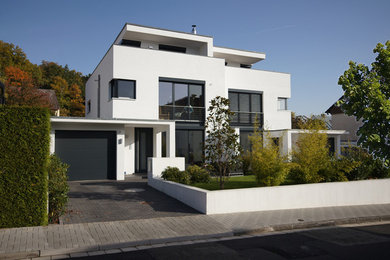 Design ideas for a white contemporary detached house in Frankfurt with a flat roof and three floors.