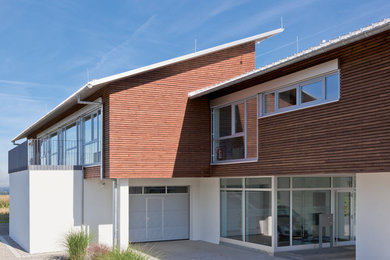 Imagen de fachada marrón contemporánea con revestimiento de madera