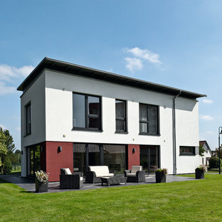 Mittelgroßes, Weißes, Zweistöckiges Modernes Einfamilienhaus mit Putzfassade, Flachdach und Ziegeldach in Sonstige