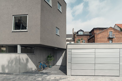 Mittelgroßes, Dreistöckiges Modernes Haus mit Mix-Fassade, grauer Fassadenfarbe und Flachdach in Sonstige