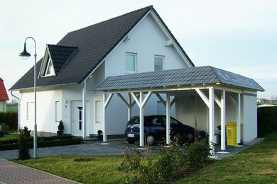 Mid-sized trendy white two-story stucco exterior home photo in Leipzig with a tile roof