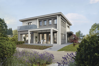 Réalisation d'une façade de maison grise design à un étage avec un toit à quatre pans.