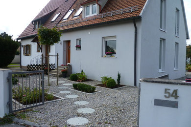 Mittelgroße, Dreistöckige Country Doppelhaushälfte mit Putzfassade, grauer Fassadenfarbe, Flachdach und Schindeldach in München