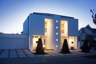 Mittelgroßes, Zweistöckiges Modernes Einfamilienhaus mit Putzfassade und weißer Fassadenfarbe in Köln